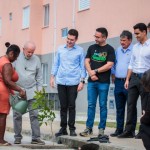 Moradora ganhadora de um apartamento do Parque da Lagoa rega a planta observada por Lula, Paulo Dantas, ministro Jader e demais autoridades